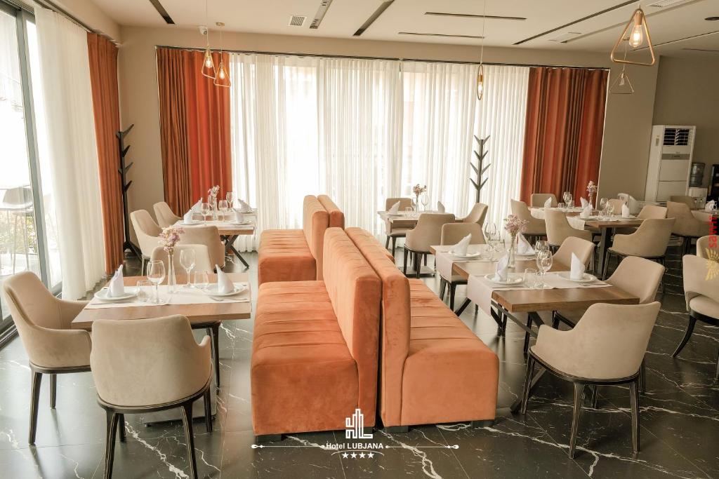 een restaurant met tafels en stoelen en een bank bij Hotel Lubjana in Durrës