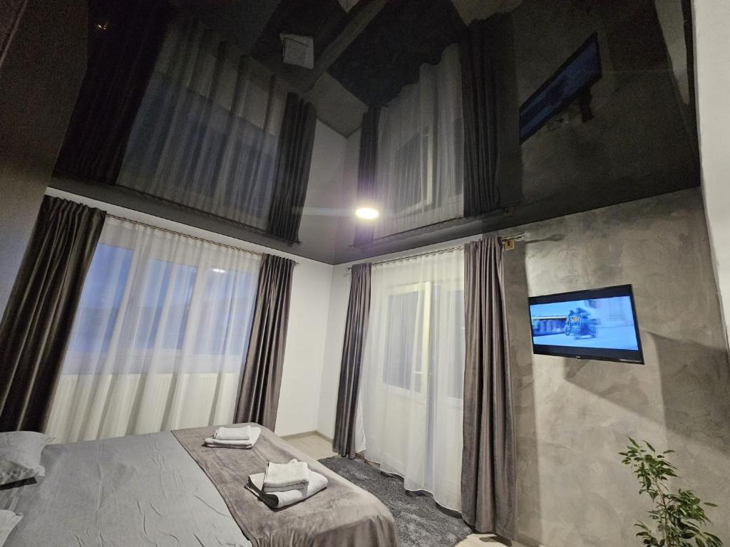 ein Schlafzimmer mit einem Bett und einem TV an der Wand in der Unterkunft Vila Noris in Iaşi