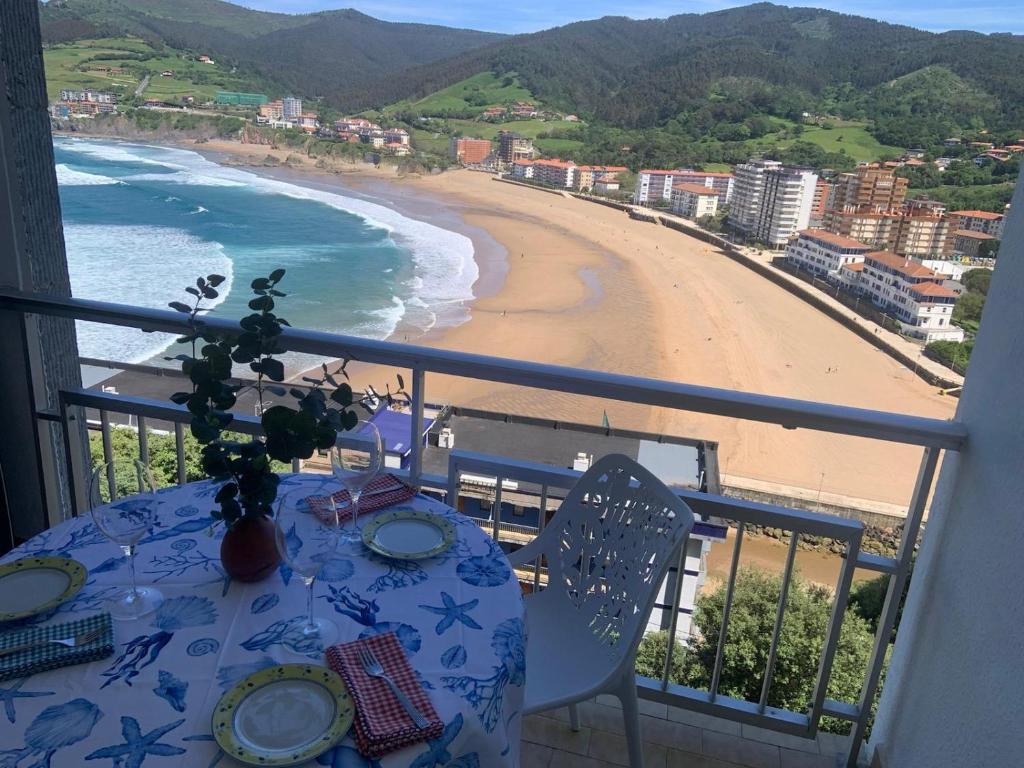 una mesa en un balcón con vistas a la playa en El BALCON DE BAKIO, en Bakio