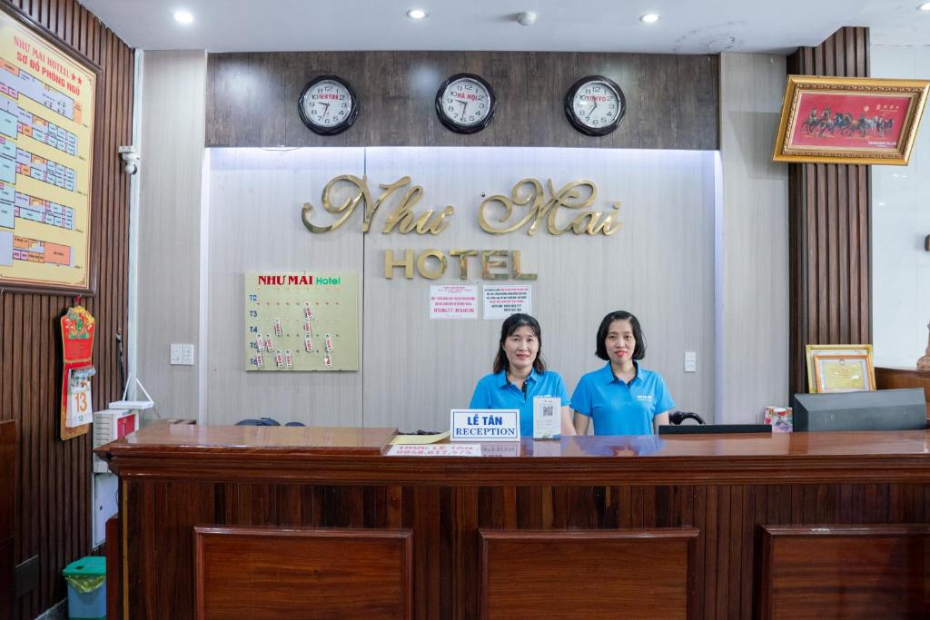 two women standing at a counter at a hotel at Khách Sạn Như Mai in Quang Tri