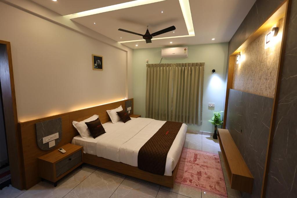 a bedroom with a bed and a ceiling fan at Riders Den in Mananthavady