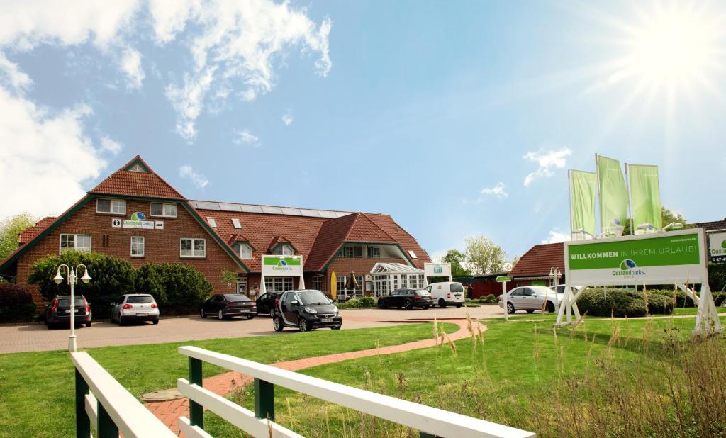 un bâtiment avec des voitures garées dans un parking dans l'établissement Cuxlandhotel Studio 122, à Dorum Neufeld