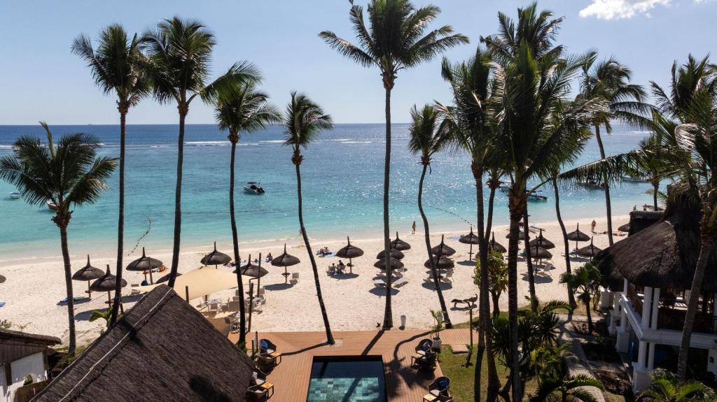 vista su una spiaggia con palme e sull'oceano di Constance Sakoa Boutik a Trou aux Biches