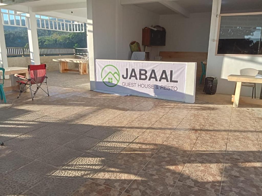 a jagi sign in a room with chairs and tables at JABAAL GUEST HOUSE and RESTO in Senaru