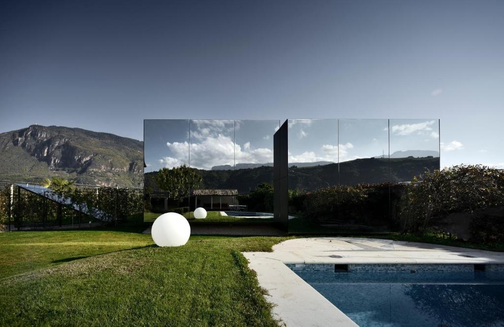 uma casa com piscina na relva em Mirror Houses em Bolzano