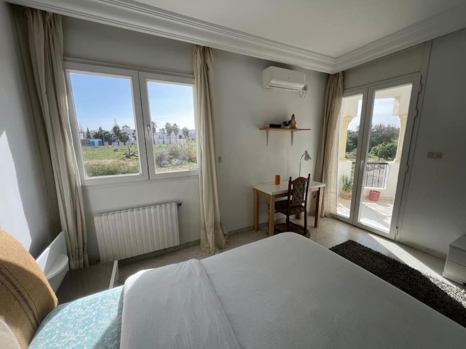 - une chambre avec un lit, un bureau et des fenêtres dans l'établissement SousseCozy apartment Chatt Meriem, à Hammam Sousse