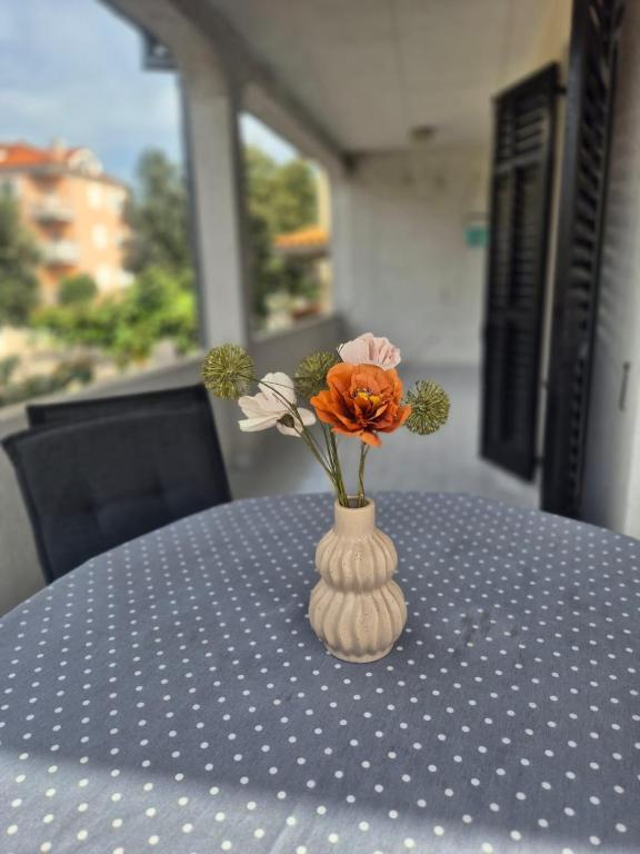 un vaso con dei fiori, seduto su un tavolo. di Apartment Vilma a Rovigno (Rovinj)