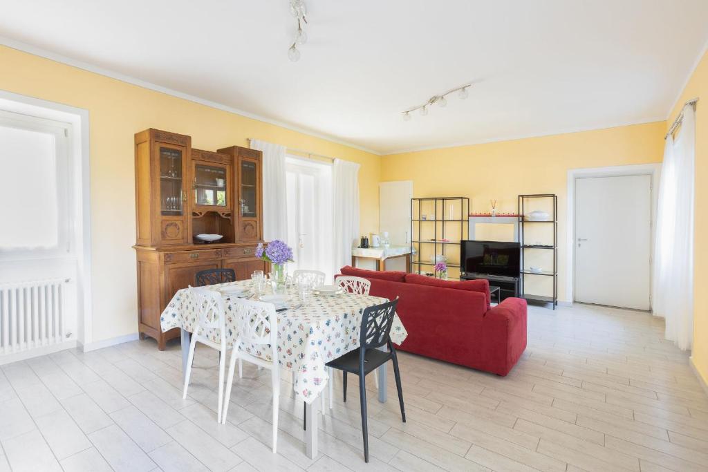 een woonkamer met een tafel en een rode bank bij Appartamento Gino in Cannero Riviera