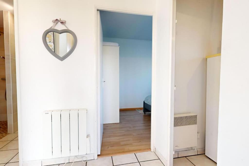 een hal met een hartvormige spiegel aan de muur bij Appartement de 51 m2 avec jardin de 51 m2, parking privé in Achères