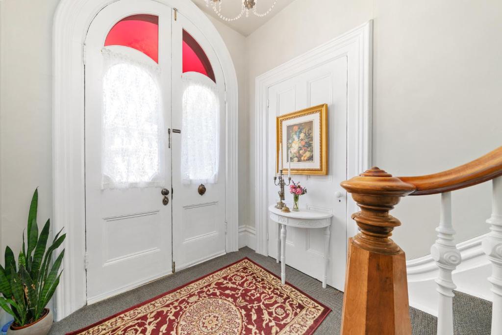 a hallway with a white door and a rug at The 1885 Suites in Picton