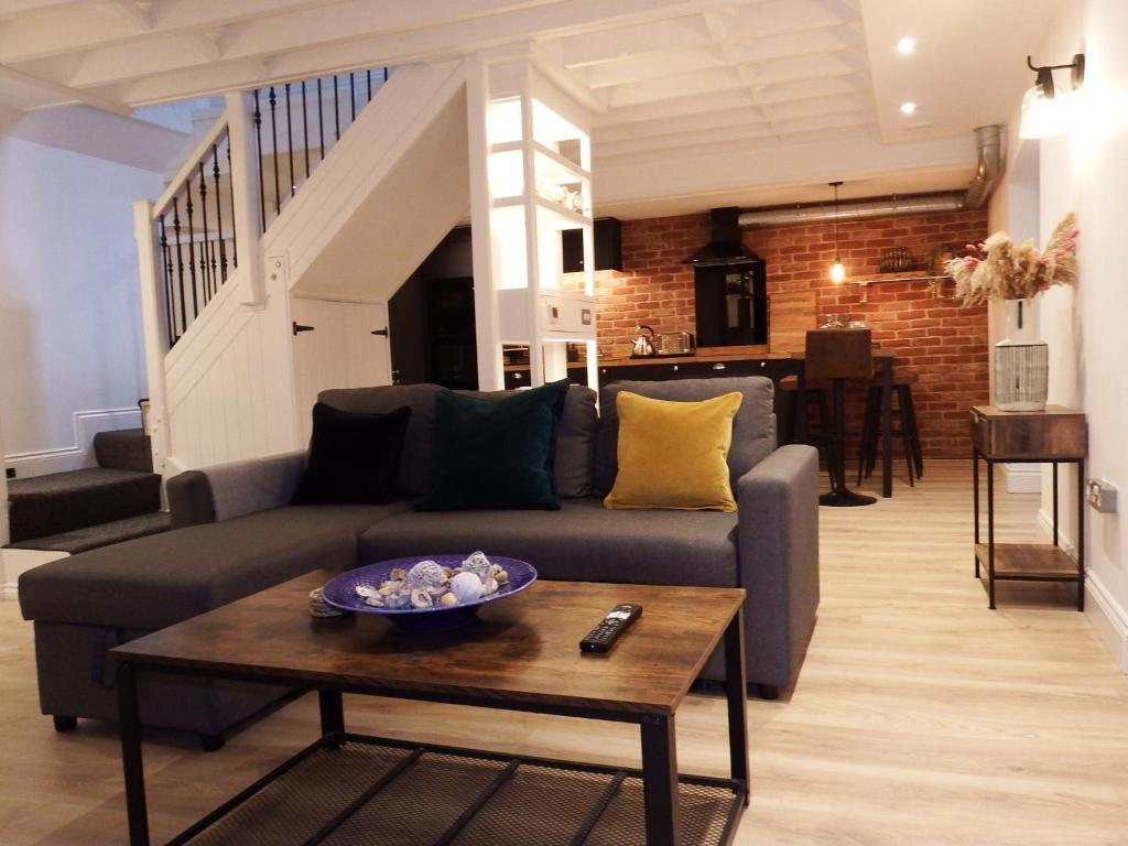 uma sala de estar com um sofá e uma mesa em Newly Renovated Stunning Warehouse Apartment em Bournemouth