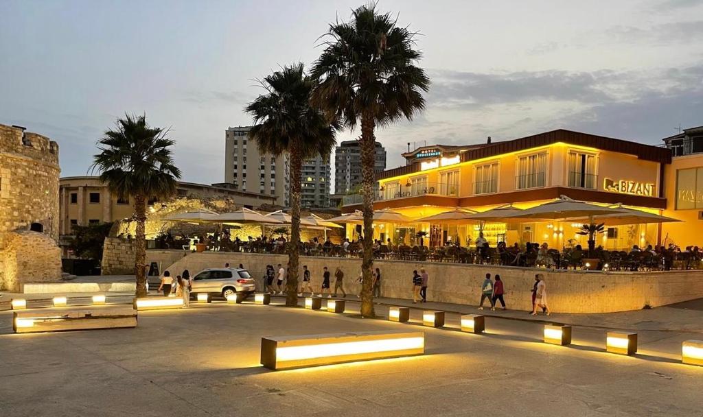 een groep mensen die voor een gebouw lopen bij Bizant Boutique Hotel & Coffee,Bar in Durrës