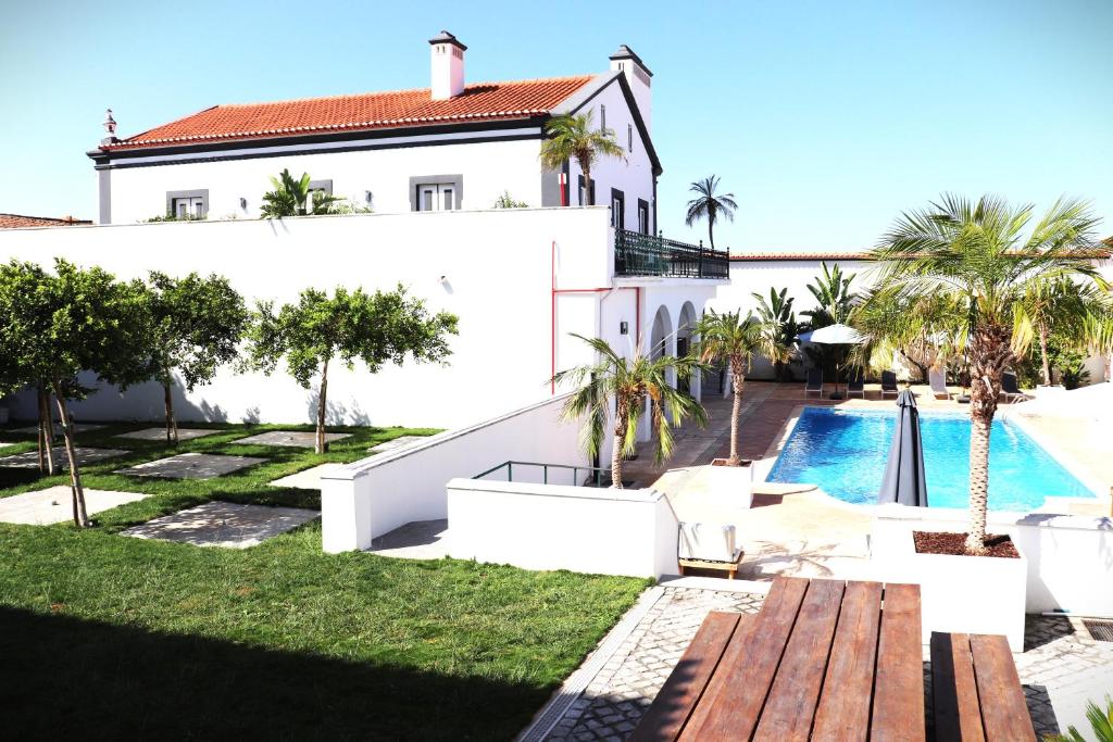 a villa with a swimming pool and a house at SOLAR DOS FRADES in Ferreira do Alentejo