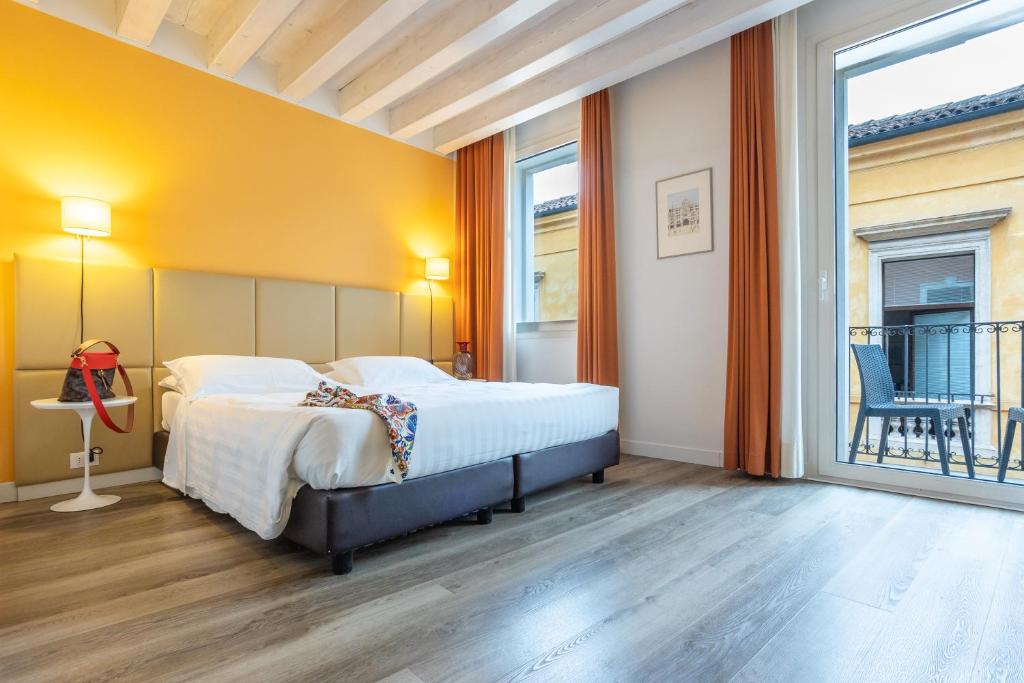 a bedroom with a bed and a large window at Relais Santa Corona in Vicenza