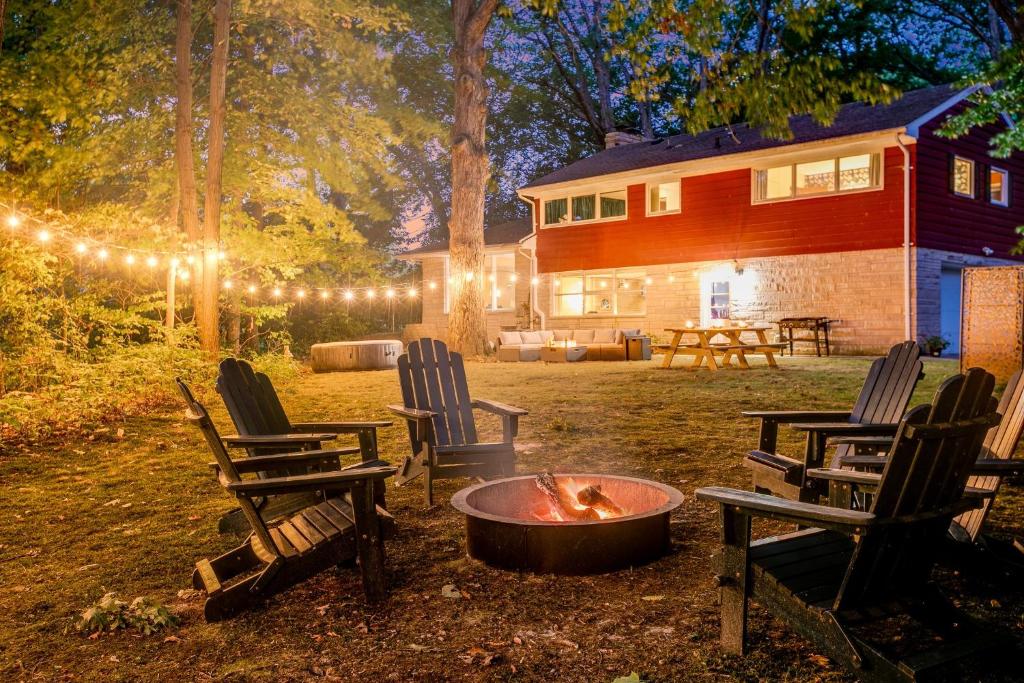 uma fogueira num quintal com cadeiras e uma casa em Unique! Retro 1950's wooded retreat near Indiana Dunes National Park em Chesterton