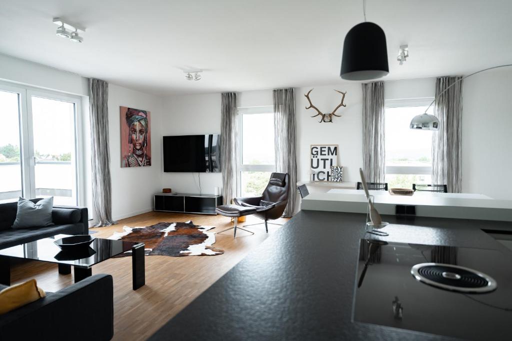 een woonkamer met meubilair en een flatscreen-tv bij Prime Park Penthouse Aschaffenburg in Aschaffenburg