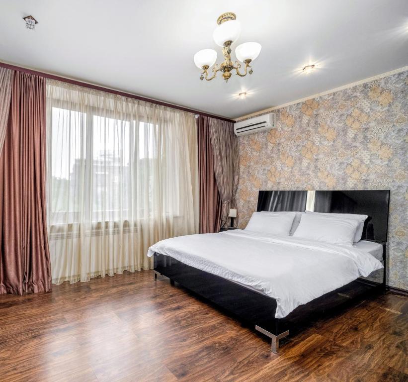 Lux Apartment Gorkiy Park في خاركوف: غرفة نوم بسرير ونافذة كبيرة