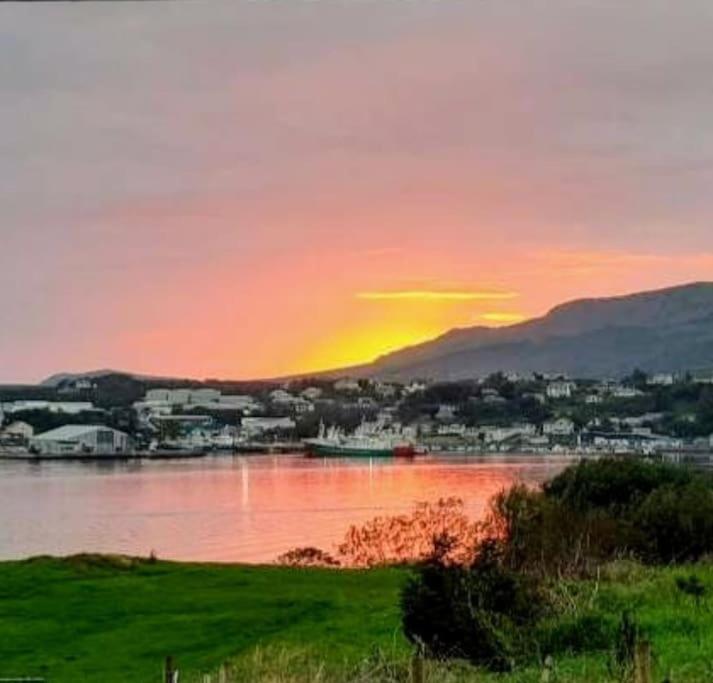 einen Sonnenuntergang über einem Wasserkörper mit einer Stadt in der Unterkunft Benroe House 5 Bedrooms in Killybegs