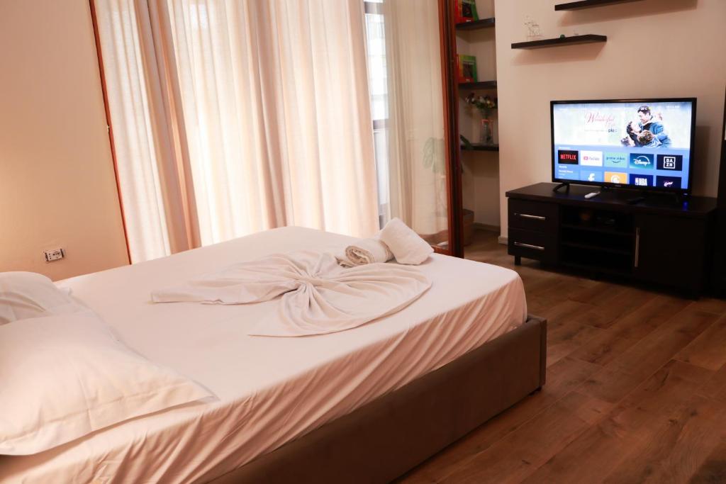 um quarto com uma cama e uma televisão de ecrã plano em Nest&Rest Studios em Tirana