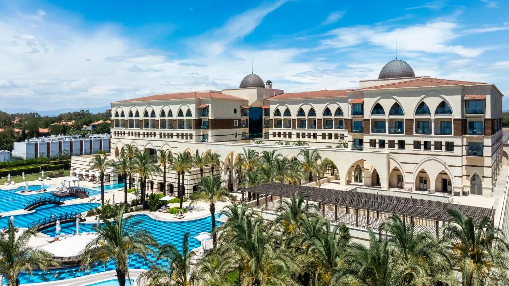 uma imagem de um resort com piscina e palmeiras em Kempinski Hotel The Dome Belek em Belek