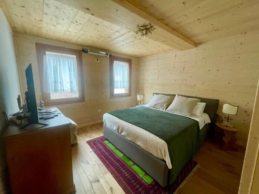 um quarto com uma cama num chalé de madeira em Nido Ampezzano em Borca di Cadore