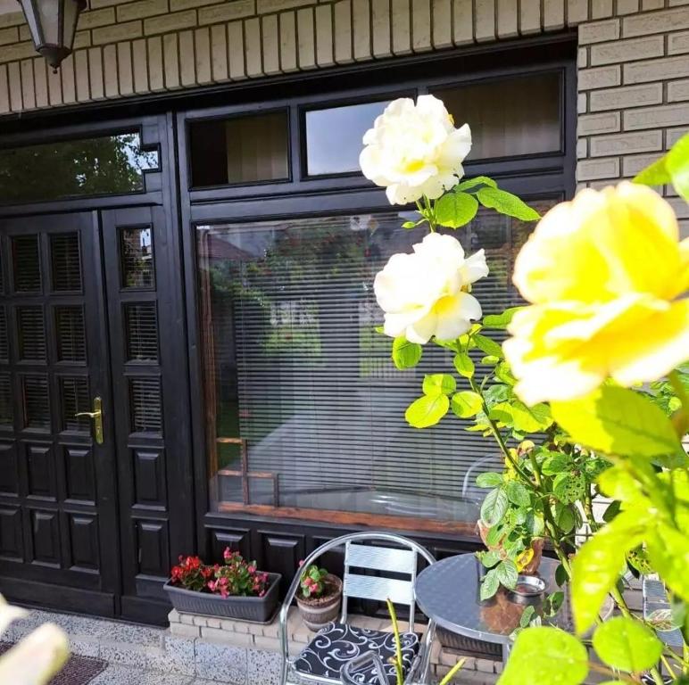 uma porta preta com uma janela, uma mesa e flores em Vila Jevtić studio 3 em Soko Banja