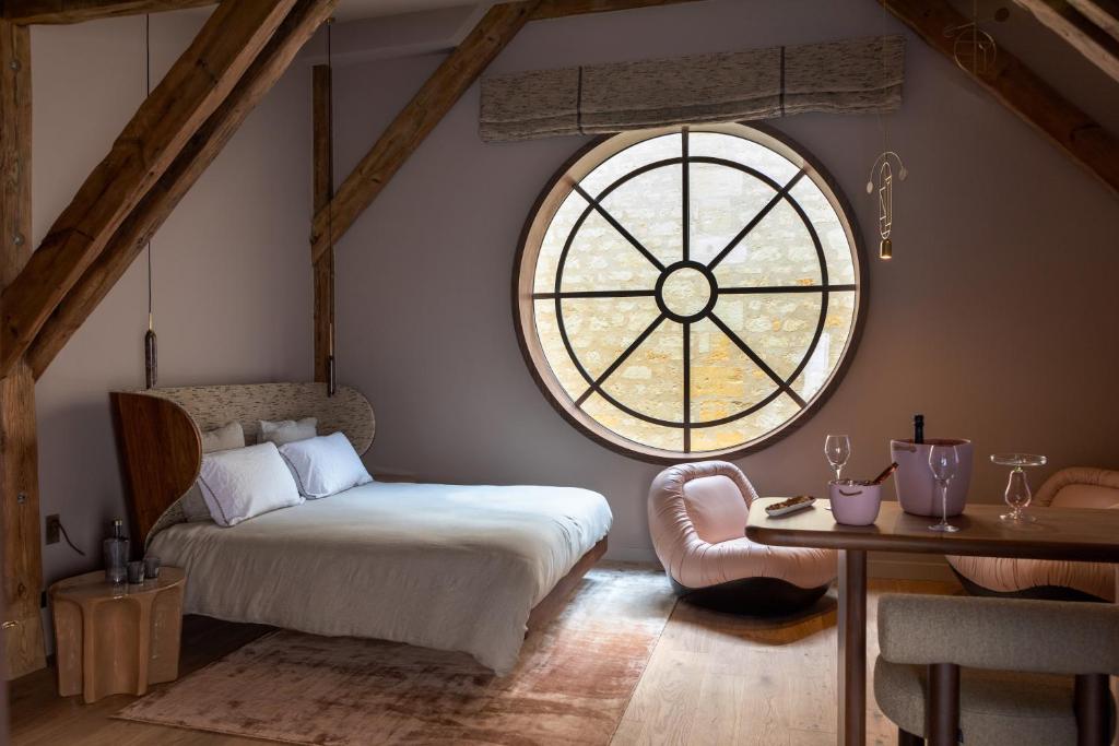 a bedroom with a bed and a large window at Yndo Hôtel in Bordeaux