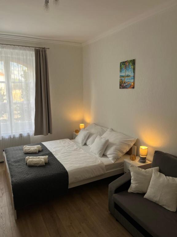 una camera con un grande letto e un divano di Széchenyi Apartman Esztergom a Esztergom