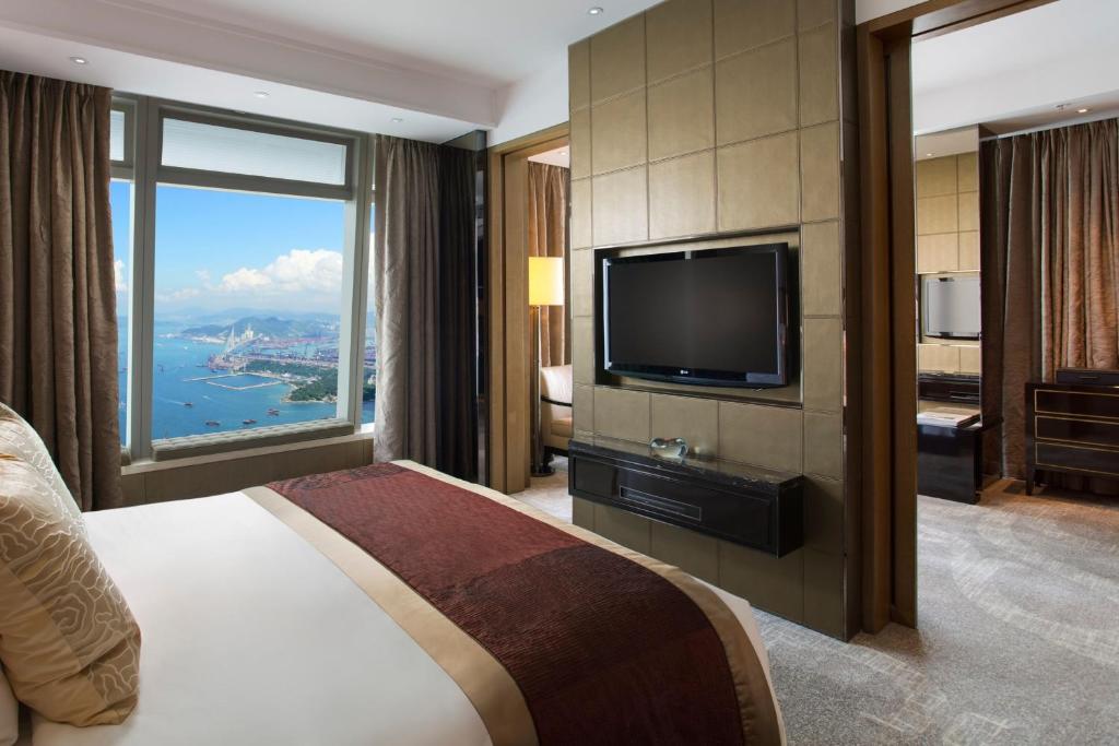 een hotelkamer met een groot bed en een televisie bij The Ritz-Carlton, Hong Kong in Hong Kong