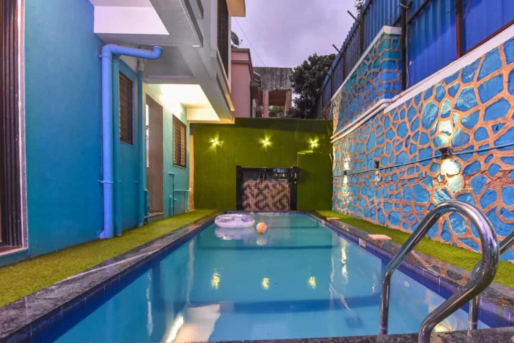 uma piscina numa casa com uma parede azul e verde em EMPYREAN STAY ll 4BHK II KOHINOOR VILLA ll PRIVATE POOL II AC II LUXURY ll TUNGARLI em Lonavala