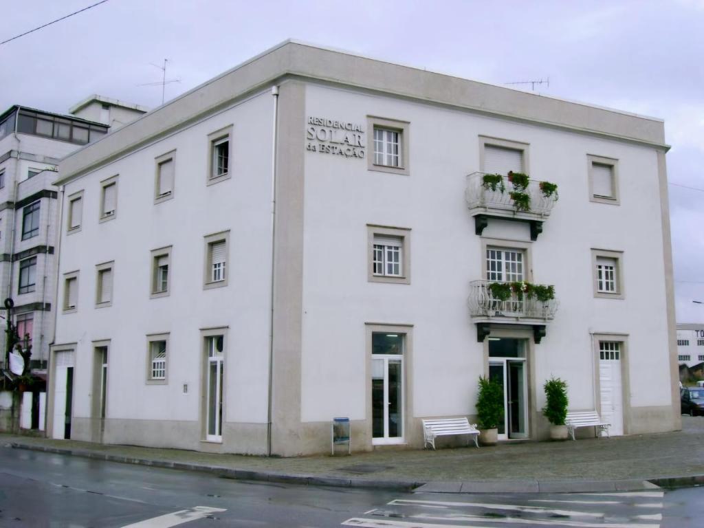 un edificio blanco al lado de una calle en Residencial Solar da Estação, en Barcelos