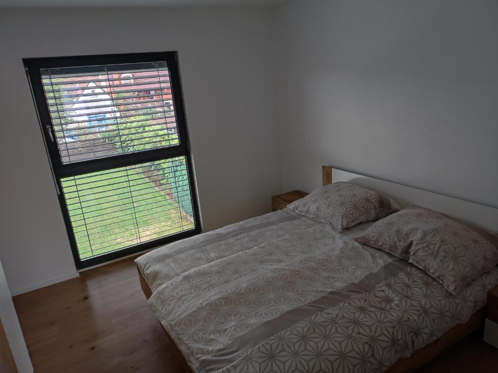 1 dormitorio con cama y ventana grande en B&D apartment, en Maribor