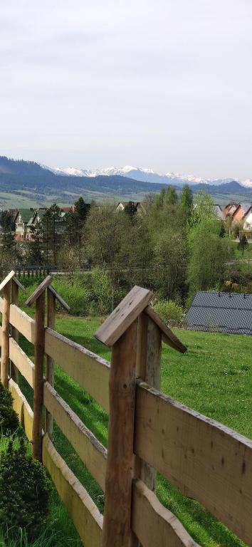 valla de madera con vistas a un campo en Góralskie Domki na Podhalu - z jacuzzi, en Maniowy