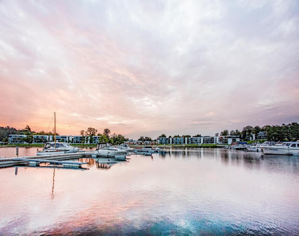 un porto turistico al tramonto con barche in acqua di Maremüritz Yachthafen Resort a Waren