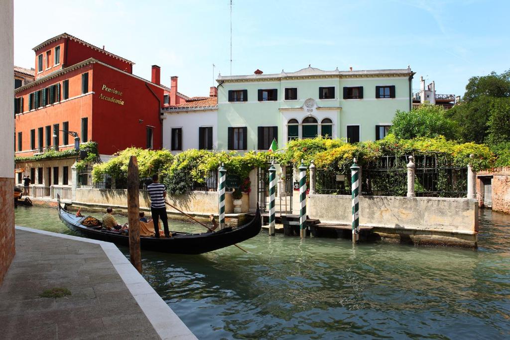 uma gôndola está ancorada num canal ao lado de edifícios em Pensione Accademia - Villa Maravege em Veneza