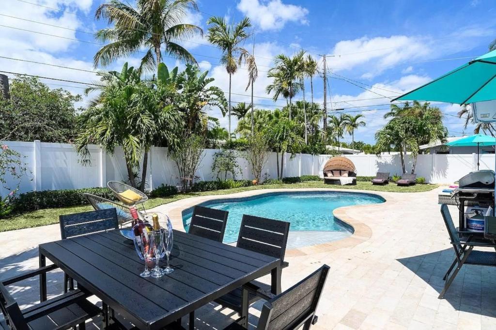 a table and chairs next to a swimming pool at Ft Lauderdale Dream in Fort Lauderdale