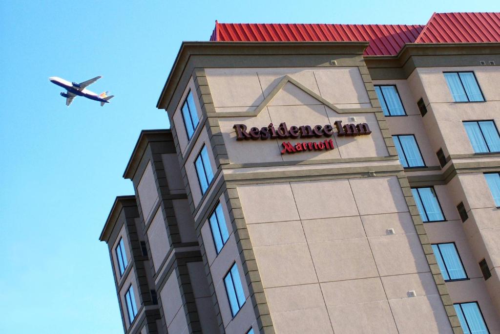 Un aereo sta volando sopra un edificio con un cartello dell'hotel di Residence Inn by Marriott Toronto Airport a Toronto