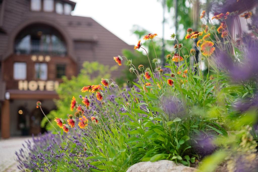 un jardin fleuri devant un bâtiment dans l'établissement Hotel Szymbark, à Szymbark