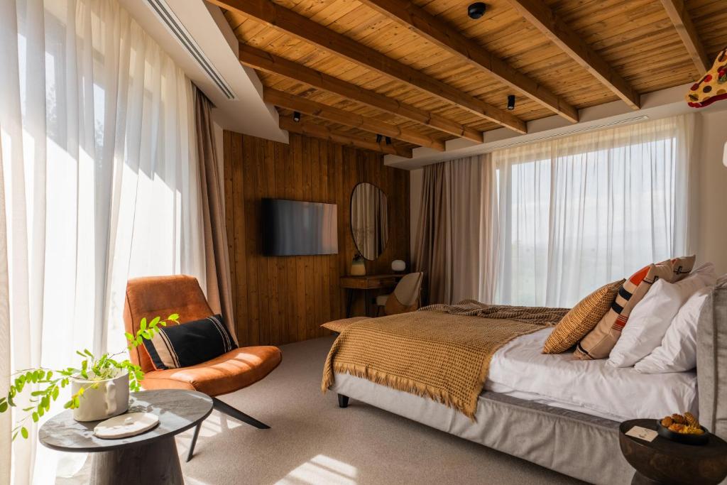 um quarto com uma cama e uma cadeira em The Pines Bucegi Lodge em Bran