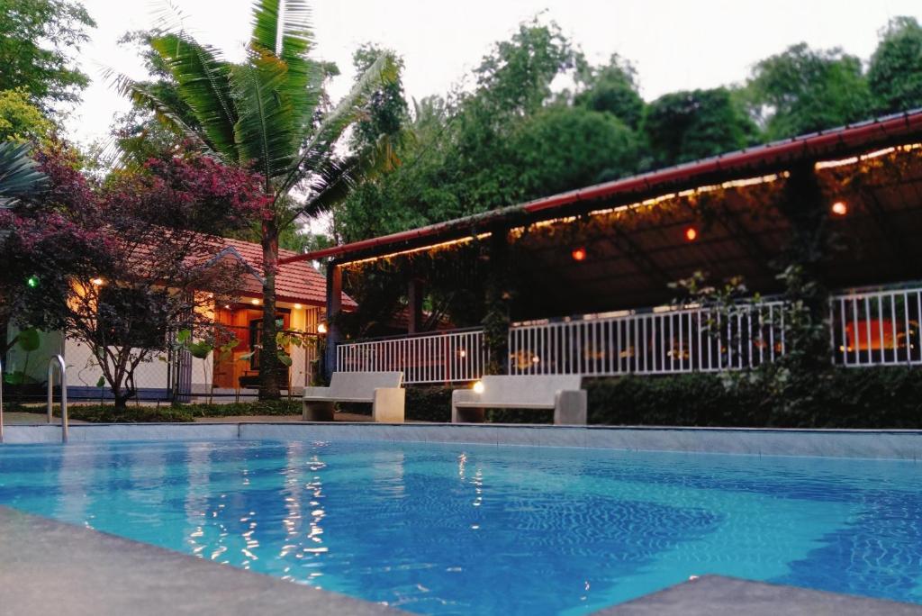 a swimming pool in front of a house at Le Eden Resort in Sultan Bathery