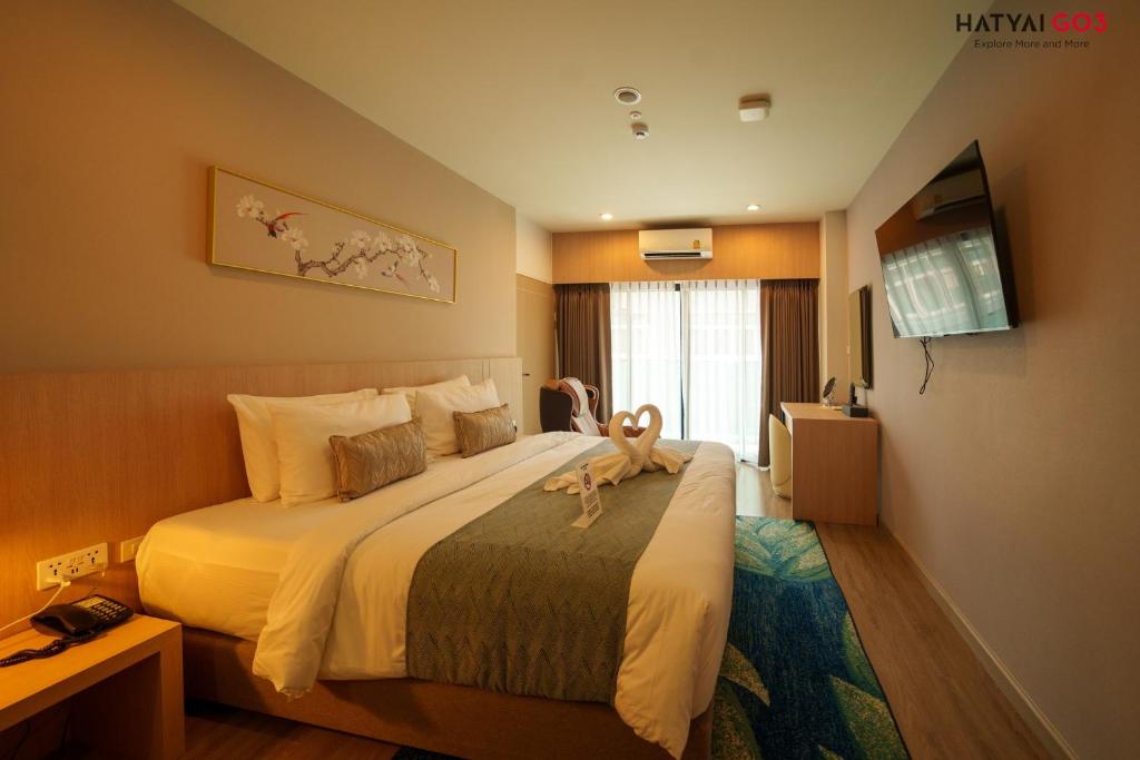 a hotel room with a bed with a stuffed animal on it at Chinatown Living Hatyai in Hat Yai