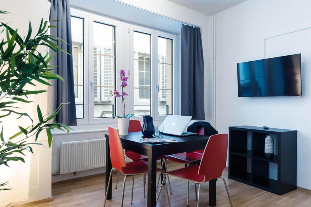 a living room with a table with chairs and a laptop at HITrental Old Town Apartments in Luzern