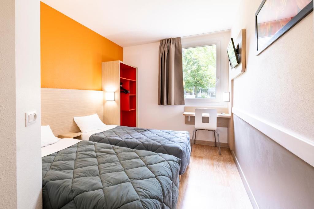 um quarto de hotel com duas camas e uma janela em Première Classe Roissy - Aéroport CDG - Le Mesnil-Amelot em Le Mesnil-Amelot