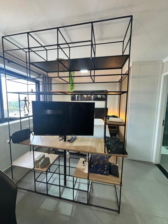 a room with a desk with a tv and a bunk bed at Flat Luxuoso Biena Sena Madureira Vila Mariana com garagem 1009 in Sao Paulo