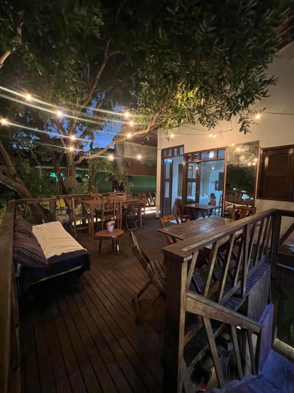 a wooden deck with tables and chairs and lights at Pousada Cafe e Mar Jeri in Jericoacoara