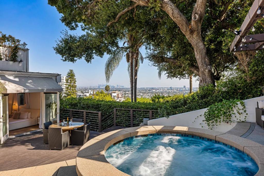 einen Außenpool mit einem Tisch und einem Baum in der Unterkunft West Hollywood Hills Jacuzzi and Beautiful View in Los Angeles