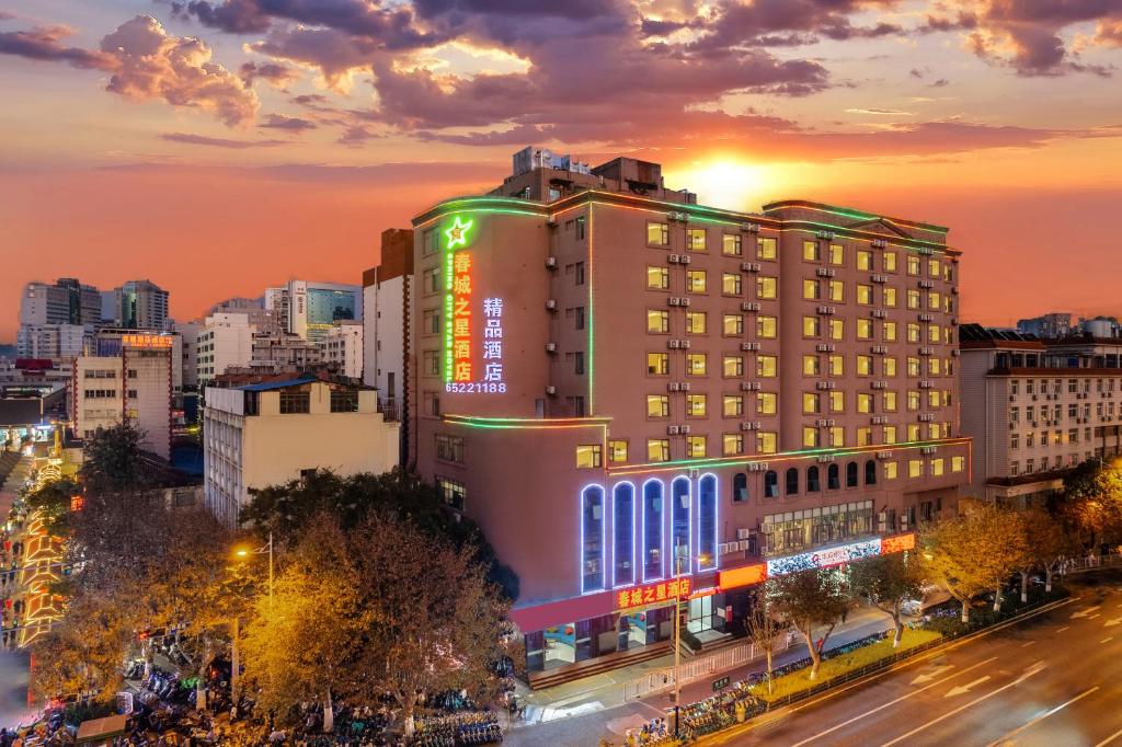 ein Gebäude in einer Stadt mit Sonnenuntergang im Hintergrund in der Unterkunft Kunming Spring City Boutique Hotel in Kunming