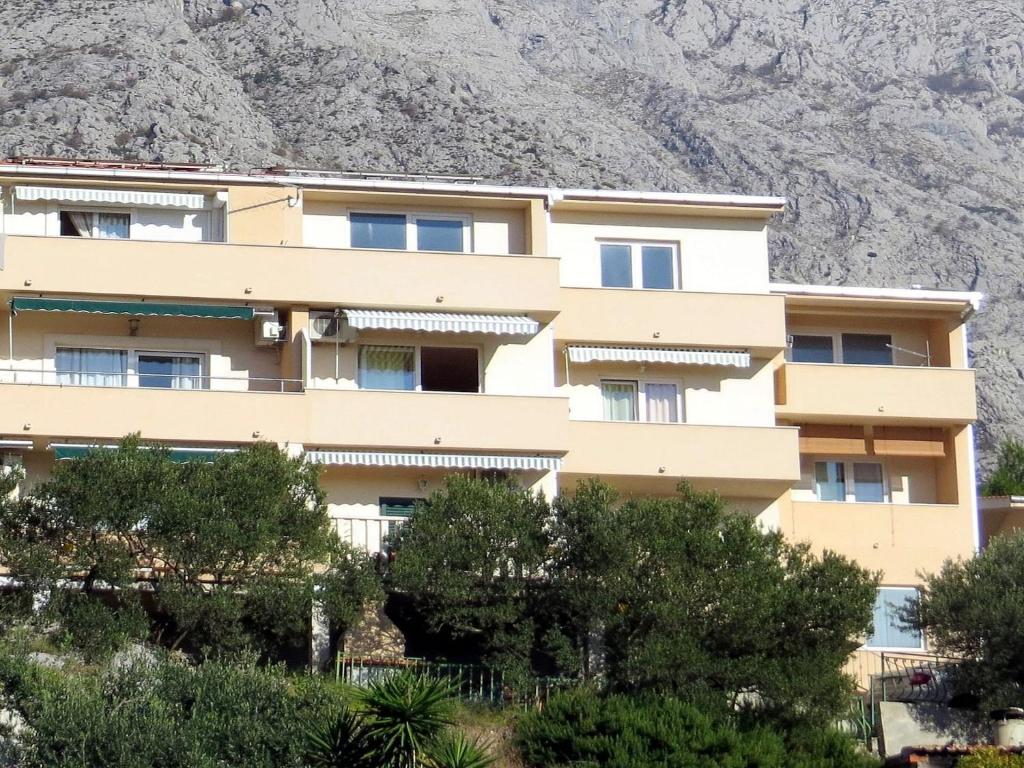 um edifício em frente a uma montanha em Apartments Marijo em Baška Voda