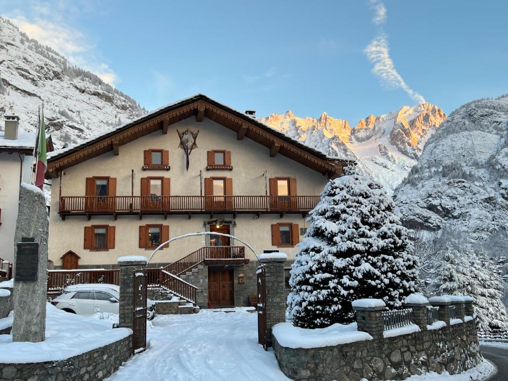 ein Haus in den Bergen mit Schnee auf dem Boden in der Unterkunft Hotel Des Glaciers in Courmayeur