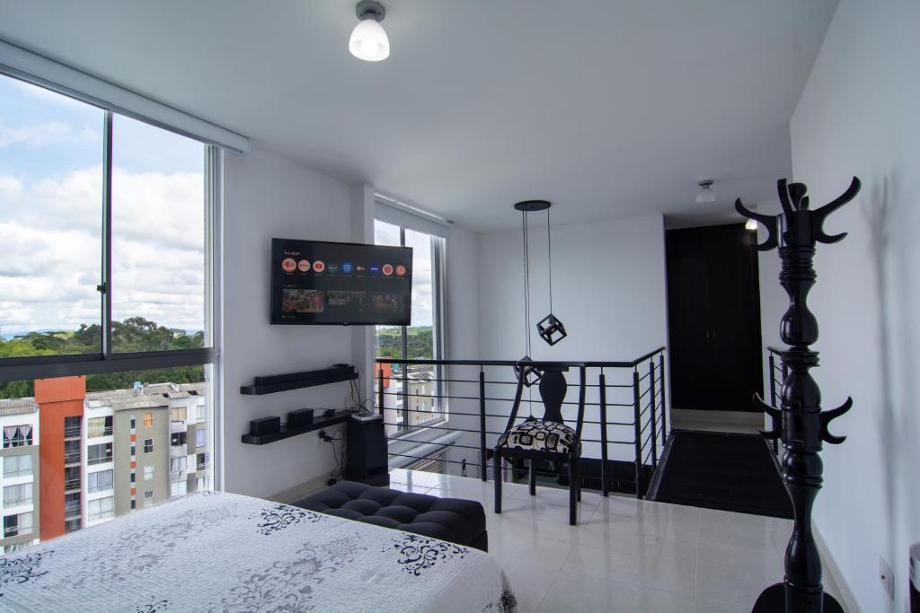 a bedroom with a bed and a balcony with a tv at EXCELENTE CONJUNTO, UBICACION PRIVILEGIADA, in Armenia